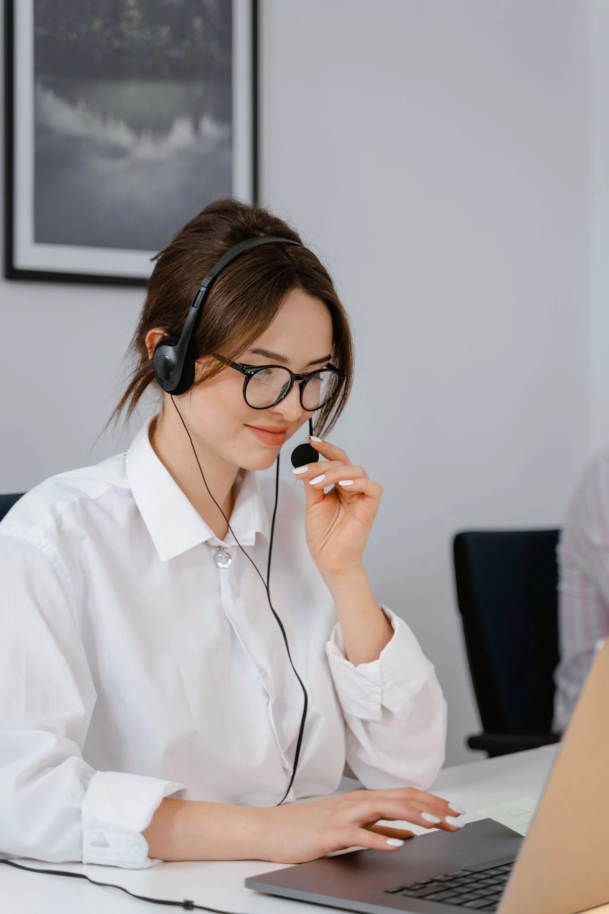 Customer-service representative using a headset while working on a laptop.