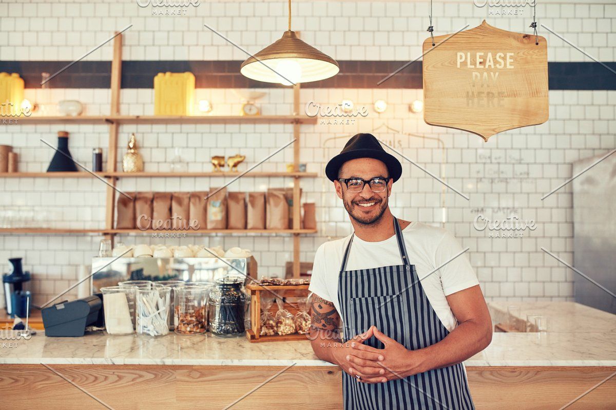 Local coffee shop owner standing confidently at the counter ready for business